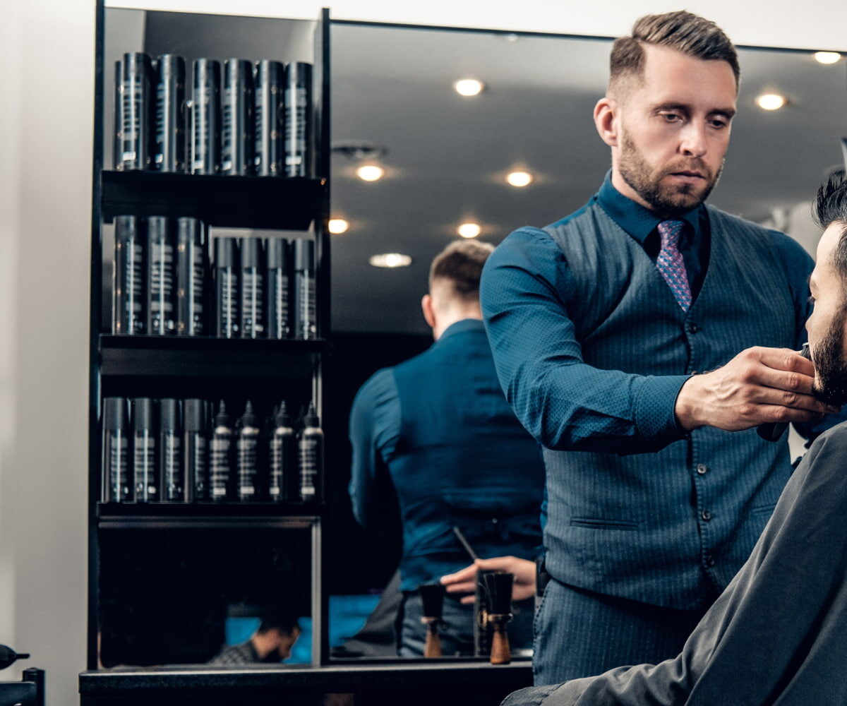 barber cutting hairs of a male customer