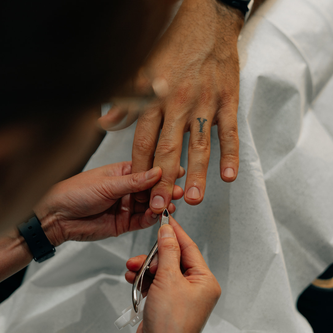 professional salon guy cutting Cut & File​ of a customer